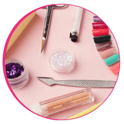 Itens e materiais de nail designer organizados sobre uma mesa rosada.